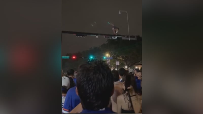 Video of the daring stunt shows a fan climbing on top of the pole at University Avenue and...