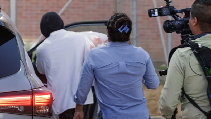 ICE Officer Christian Castro gets into a car surrounded by reporters after he was released...