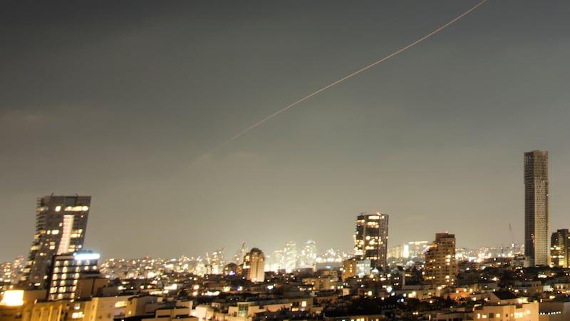 A projectile streaks through the sky over central Israel during an Iranian missile attack,...