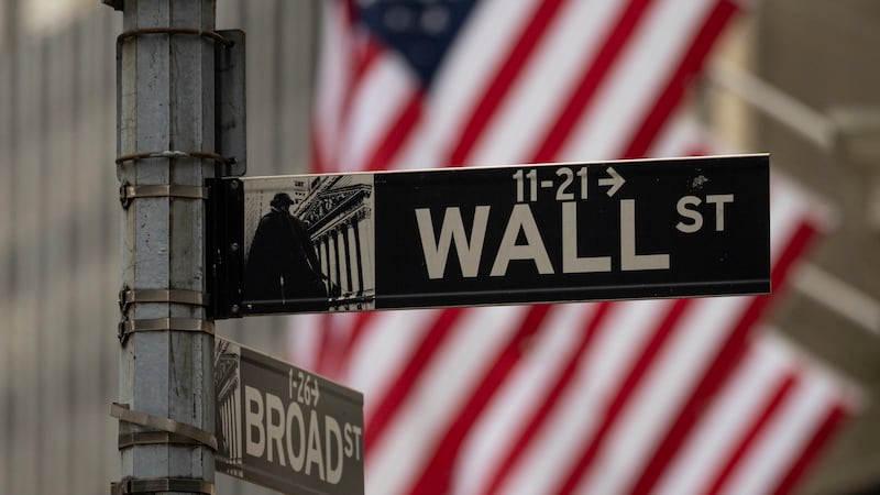 A Wall Street sign hangs near to the New York Stock Exchange, Wednesday, June 18, 2025, in New...