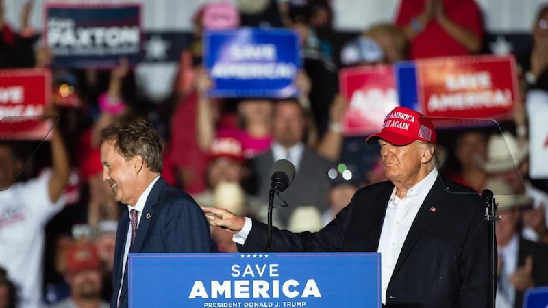 Then-former President Donald Trump pats Texas Attorney General Ken Paxton on the shoulder as...